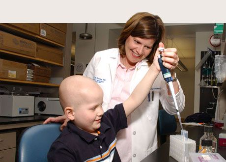 a child working with an adult scientist