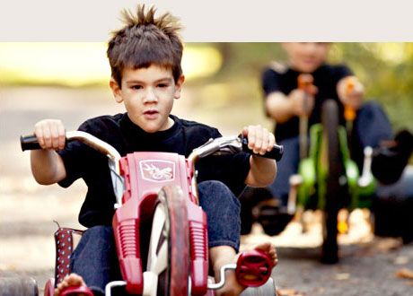two young boys riding tricycles